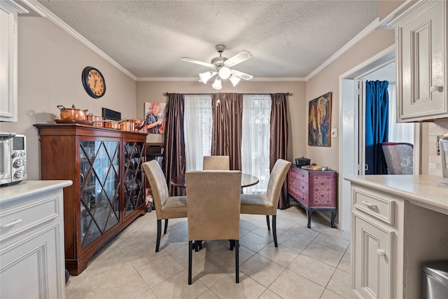 dining area with ornamental molding, a textured ceiling, light tile patterned floors, and ceiling fan