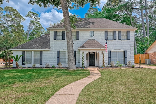 colonial inspired home with central AC unit and a front lawn