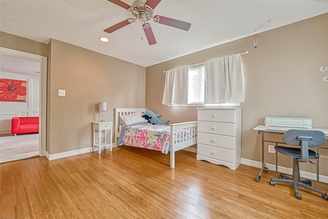 bedroom featuring a textured ceiling, ceiling fan, and light hardwood / wood-style floors