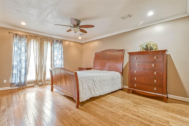 bedroom featuring ceiling fan, light hardwood / wood-style floors, a textured ceiling, and ornamental molding