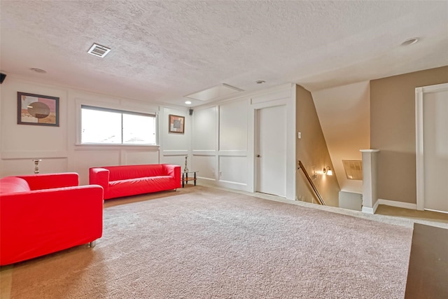 carpeted living room featuring a textured ceiling