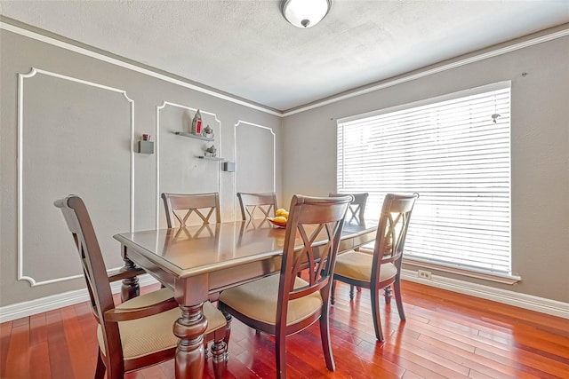 dining space with crown molding, a textured ceiling, and wood-type flooring