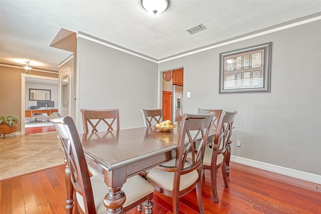 dining area featuring hardwood / wood-style flooring and ornamental molding