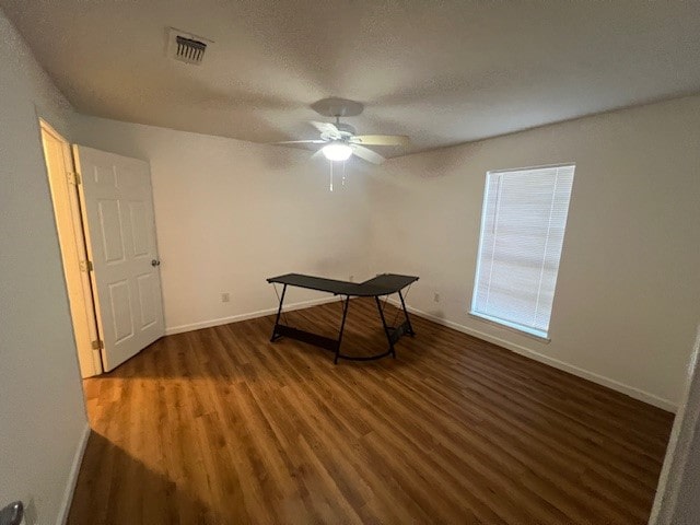 interior space with ceiling fan, dark hardwood / wood-style floors, and a textured ceiling