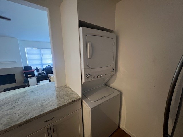 clothes washing area featuring stacked washer and dryer