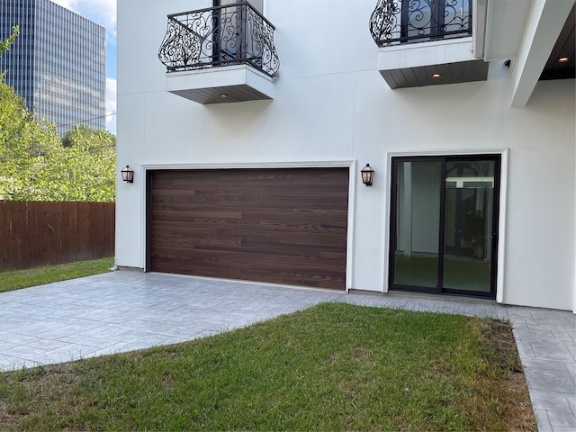 exterior space featuring a yard, a garage, and a balcony