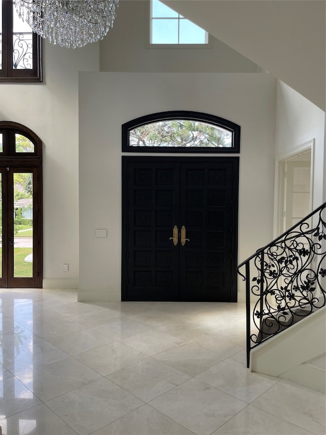 entryway with a chandelier and a towering ceiling