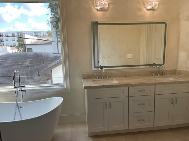 bathroom with tile patterned flooring, vanity, and a bath