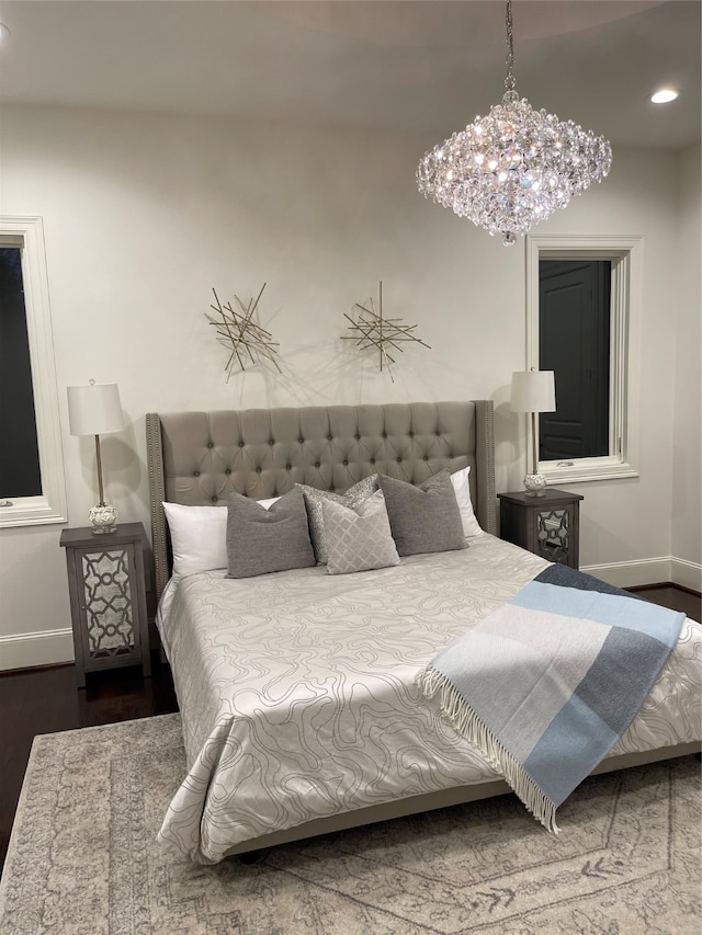 bedroom with wood-type flooring and a notable chandelier