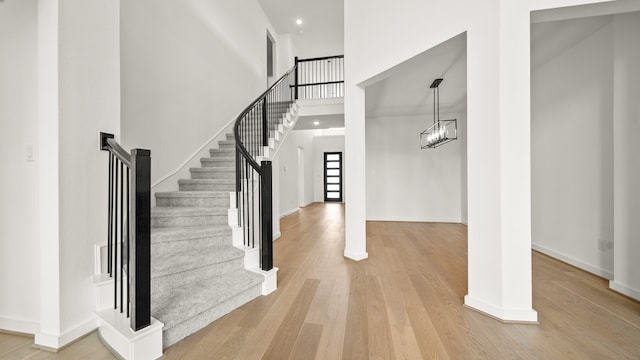 foyer with a chandelier, hardwood / wood-style floors, and a high ceiling