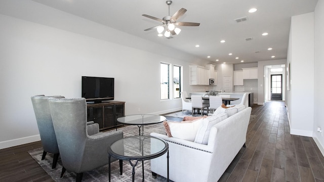 living room with dark hardwood / wood-style flooring and ceiling fan