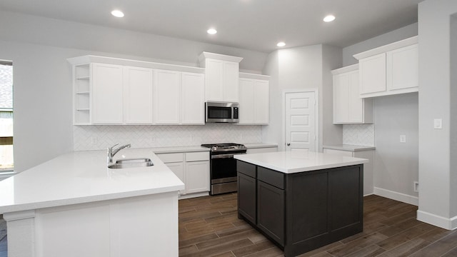 kitchen featuring white cabinets, a kitchen island, sink, and stainless steel appliances