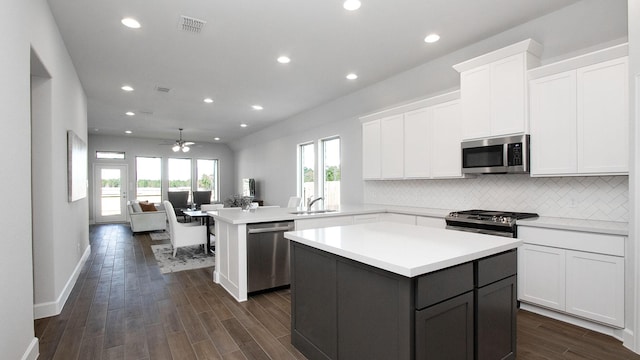 kitchen with ceiling fan, sink, a center island, kitchen peninsula, and appliances with stainless steel finishes