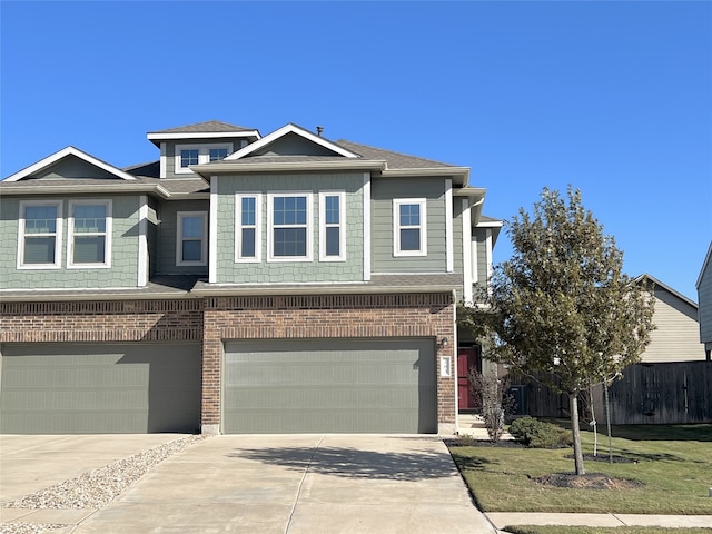 view of front of home with concrete driveway, brick siding, fence, and an attached garage