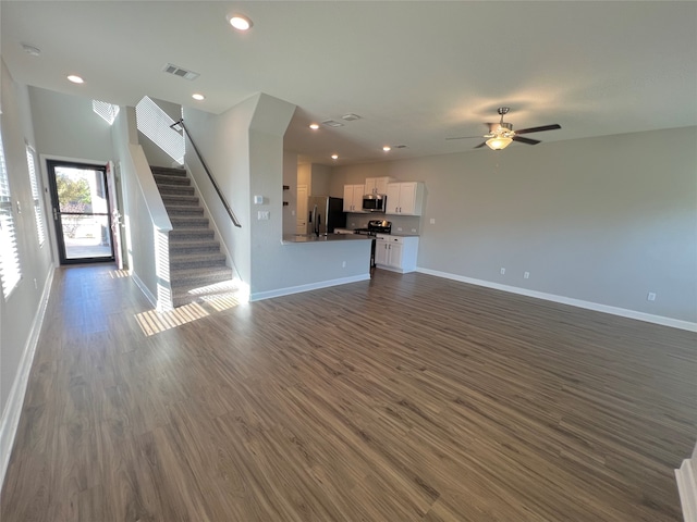 unfurnished living room featuring ceiling fan and dark wood-type flooring