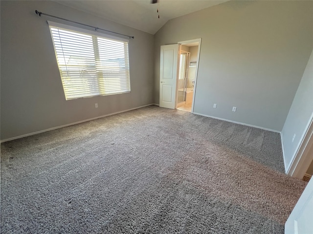 unfurnished bedroom with carpet flooring, lofted ceiling, and ensuite bath