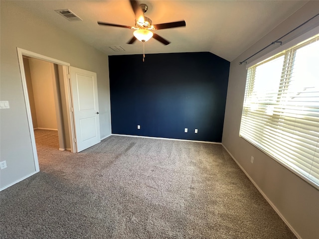 carpeted empty room featuring vaulted ceiling and ceiling fan