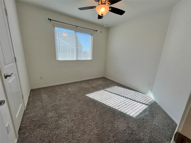 empty room with ceiling fan and dark carpet