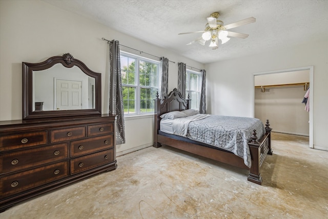 bedroom with a closet, ceiling fan, a spacious closet, and a textured ceiling