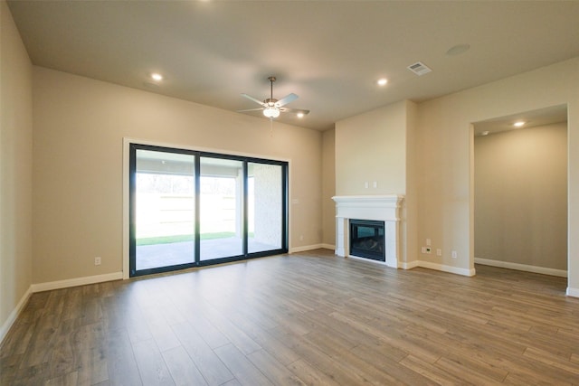 9715 Hunters Run Dr, Missouri City, TX 77459 - unfurnished living room featuring visible vents, wood finished floors, baseboards, and a glass covered fireplace