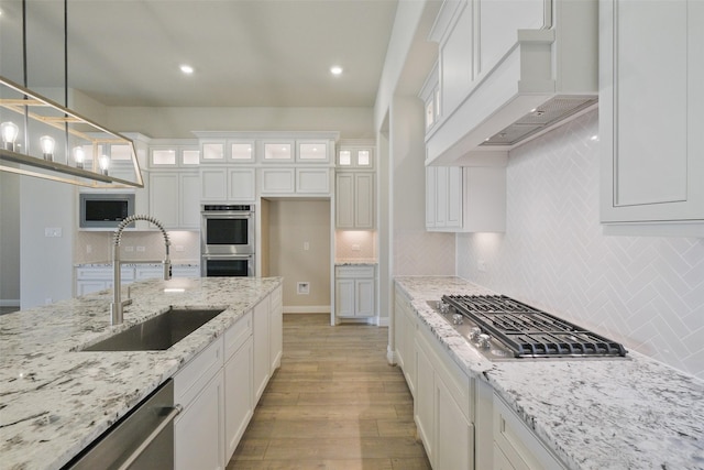 9715 Hunters Run Dr, Missouri City, TX 77459 - kitchen featuring a sink, custom range hood, white cabinets, and stainless steel appliances