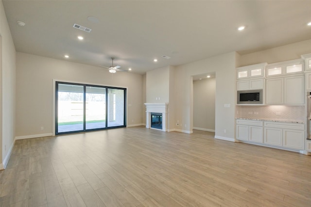 9715 Hunters Run Dr, Missouri City, TX 77459 - unfurnished living room with visible vents, light wood finished floors, recessed lighting, ceiling fan, and a glass covered fireplace