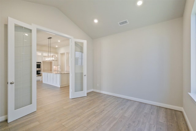 9715 Hunters Run Dr, Missouri City, TX 77459 - unfurnished room with visible vents, light wood-style flooring, a sink, french doors, and lofted ceiling