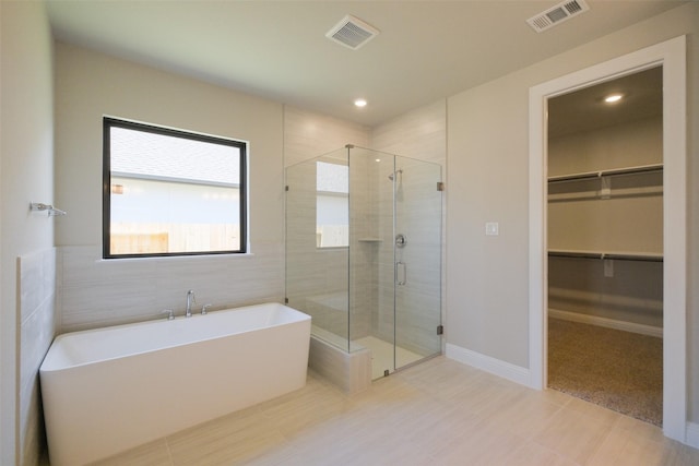 9715 Hunters Run Dr, Missouri City, TX 77459 - bathroom with a walk in closet, a soaking tub, visible vents, and a stall shower