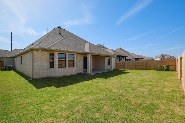 9715 Hunters Run Dr, Missouri City, TX 77459 - back of property with a yard, brick siding, roof with shingles, and a fenced backyard