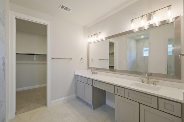 bathroom featuring a spacious closet, visible vents, and a sink