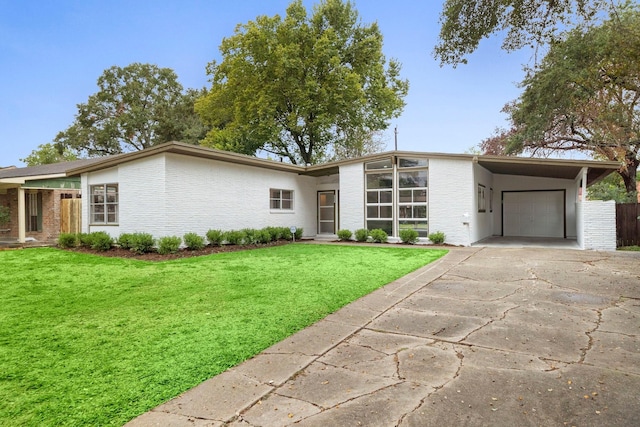 ranch-style home featuring a carport, a garage, and a front lawn