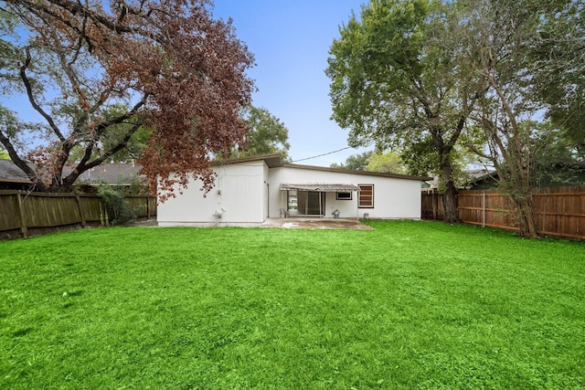 rear view of property featuring a patio area and a lawn