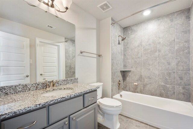 full bathroom featuring vanity, tiled shower / bath combo, toilet, and tile patterned flooring