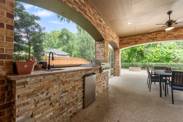 view of patio / terrace featuring ceiling fan, area for grilling, an outdoor kitchen, and sink