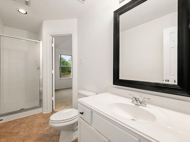 bathroom with tile patterned flooring, vanity, toilet, and a shower with door