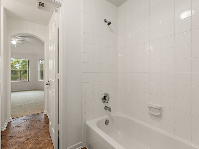 bathroom with ceiling fan, tile patterned flooring, and tiled shower / bath