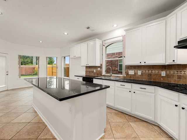 kitchen with a healthy amount of sunlight, white cabinetry, and backsplash