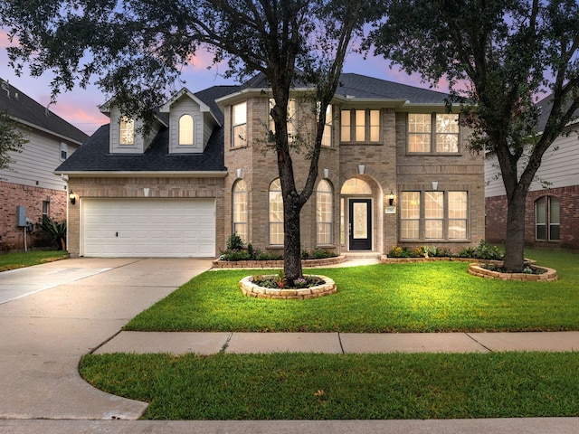 view of front of property featuring a garage and a lawn