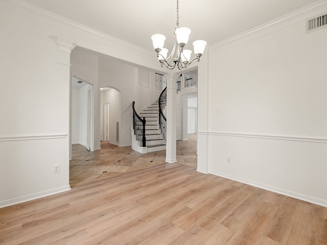 unfurnished dining area with light hardwood / wood-style floors, crown molding, and a notable chandelier