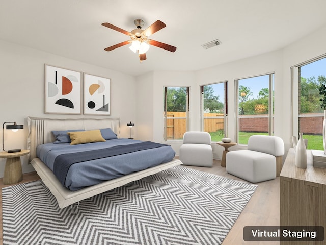 bedroom featuring light hardwood / wood-style floors, multiple windows, and ceiling fan