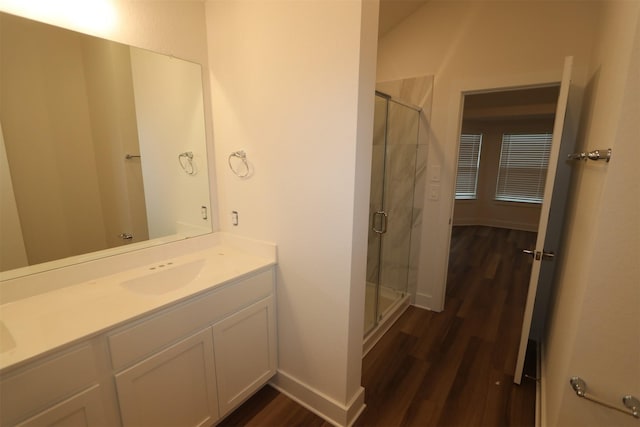 bathroom with hardwood / wood-style floors, walk in shower, and vanity