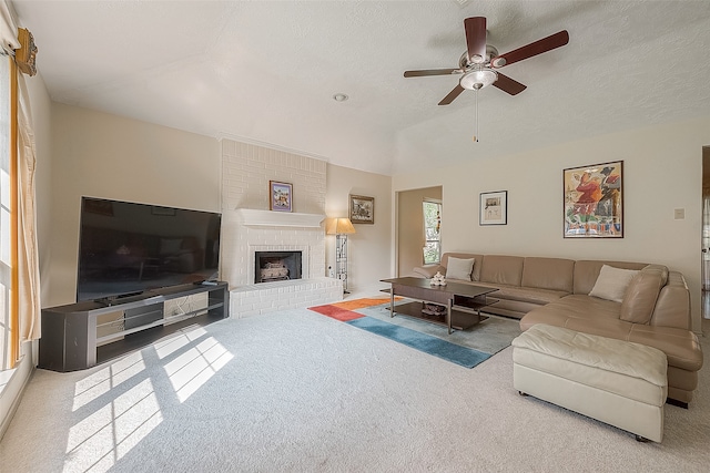 living room featuring carpet flooring, ceiling fan, a textured ceiling, and a brick fireplace