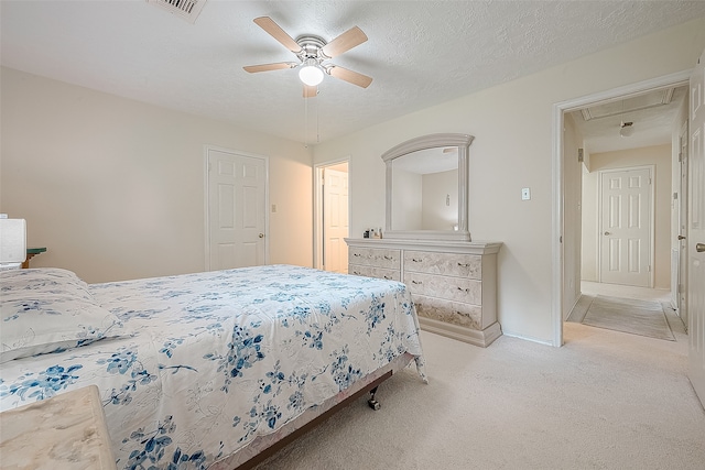 carpeted bedroom featuring ceiling fan and a textured ceiling