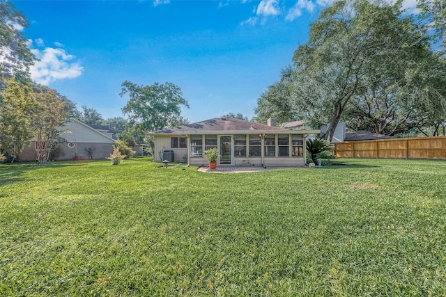 rear view of house featuring a yard and a sunroom