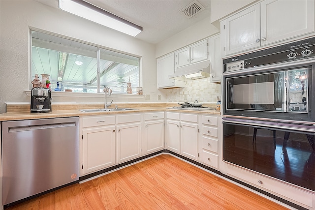 kitchen with white cabinetry, sink, backsplash, light hardwood / wood-style floors, and black appliances