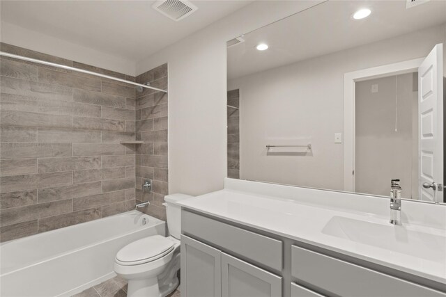 full bathroom featuring tile patterned flooring, vanity, toilet, and tiled shower / bath