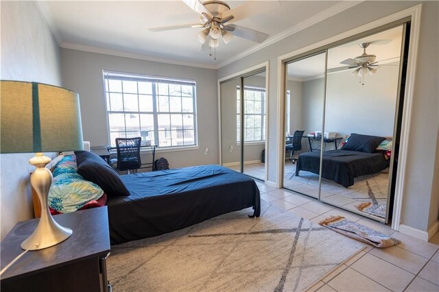 tiled bedroom with two closets, ceiling fan, and crown molding