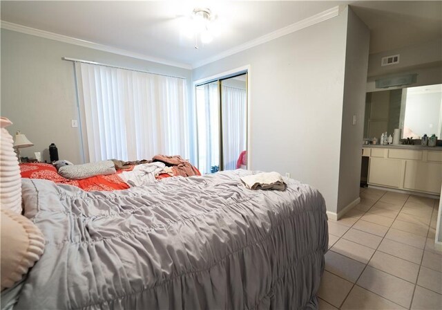 tiled bedroom featuring ornamental molding and a closet