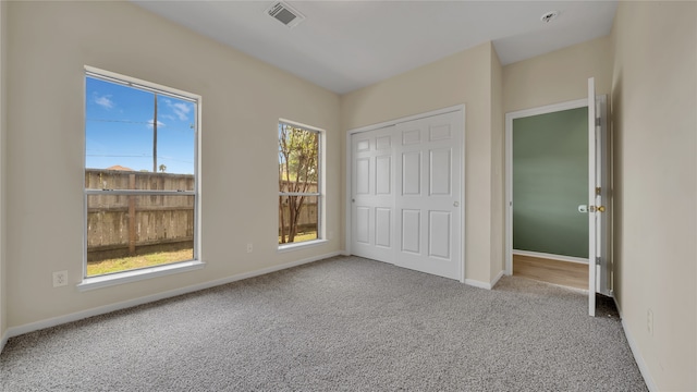 unfurnished bedroom featuring a closet and light colored carpet