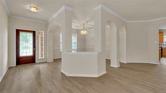 entryway with light wood-type flooring, an inviting chandelier, and ornamental molding